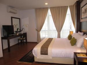 珍拉丁萨姆苏里亚海滩度假酒店的一间卧室配有一张大床、书桌和窗户