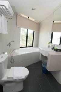 珍拉丁萨姆苏里亚海滩度假酒店的浴室配有卫生间、浴缸和水槽。
