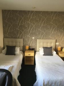 TurriffDeveron Lodge Guest House的配有衬衫的酒店客房内的两张床