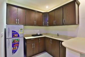 达曼Lamssat El saada的厨房配有木制橱柜和白色冰箱。