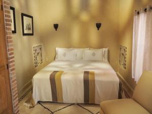 马拉喀什厄尔帕夏酒店的一间卧室配有一张床和一把椅子