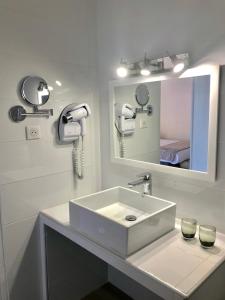 波尔图Hôtel Le Golfe Ecolabel EU的白色的浴室设有水槽和镜子