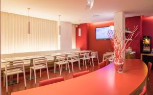 巴塞罗那老城酒店的一间拥有红色墙壁和桌椅的用餐室