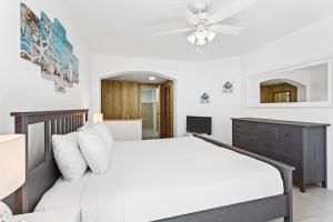 Meads BayTurtle's Nest Beach Resort的卧室配有白色的床和吊扇