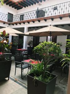 瓦哈卡市Hotel Casa las Mercedes的一个带桌椅和遮阳伞的户外庭院。