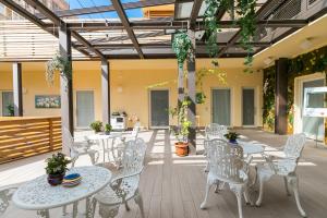 罗马Demetra Eco Guest House的庭院配有白色的桌椅和植物