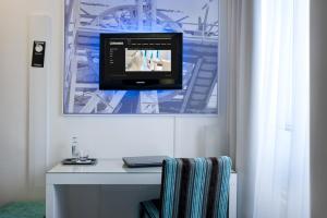 亨克爱酷酒店的一间设有一张桌子的房间,墙上有一台电视机