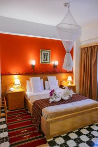 卢克索卢克索杰济拉花园酒店的一间卧室配有一张橙色墙壁的床
