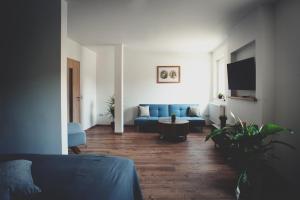 爱尔福特Übernacht Erfurt的客厅配有蓝色的沙发和电视