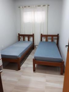 弗洛里亚诺波利斯Monsal Casa para Temporada的客房内的两张床,上面有蓝色的床单