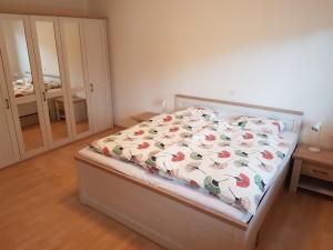 埃格尔金根Gästehaus Luma的一间卧室配有一张带花卉床罩的床