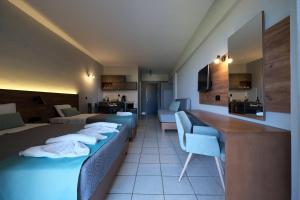 耶奥伊乌波利斯波莱达斯公寓式酒店的酒店客房带两张床和一张桌子以及椅子。