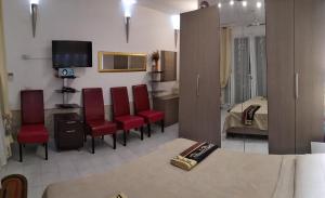 雷阿尔蒙特Appartamento Residence Canalotto的一间带红色椅子的客厅和一间卧室