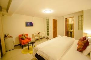 库斯科Wayta Inn的配有床、椅子和桌子的酒店客房