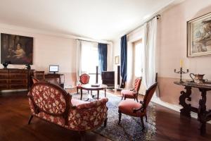 马真塔赛事酒店的客厅配有椅子和桌子
