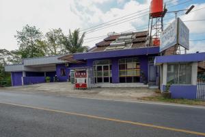 KebumenRedDoorz near RSUD Kebumen的街道边的蓝色建筑,设有加油站