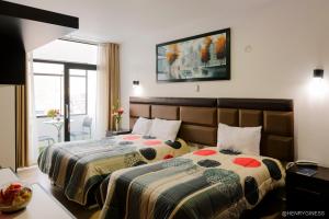 塔尔马Hotel Turin的一间卧室设有两张床和窗户。