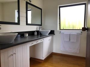 芒奥努伊Harbour View Retreat Mangonui的一间带两个盥洗盆的浴室和一个大窗户
