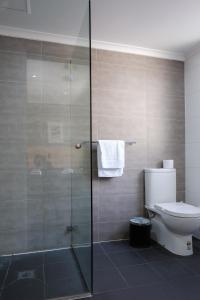 悉尼皇家展览酒店的一间带卫生间和玻璃淋浴间的浴室