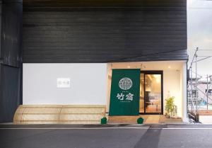 大阪Hostel Takeyado的建筑的一侧有绿色标志