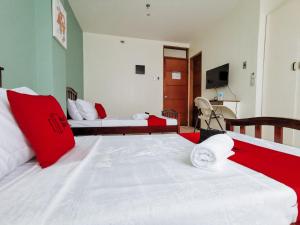 达沃市RedDoorz Plus near Bangko Sentral Ng Pilipinas Davao的一间卧室配有两张带红白色枕头的床