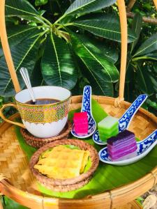 彭世洛Baan Sithepaban Guesthouse的一大篮子的颜色不同的甜点和一杯咖啡