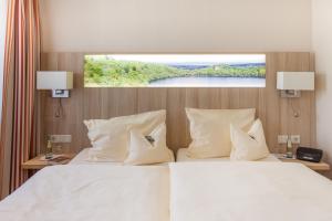 沙尔肯梅伦Eifel Hotel Schneider am Maar GmbH的卧室配有一张大白色床和窗户