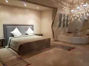 塔鲁丹特Palais Villa Talaa Resort的一间卧室配有一张床和浴缸