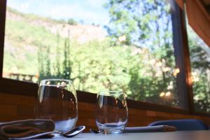 维拉诺瓦卡萨阿卡斯酒店的两杯酒杯坐在桌子上,窗户