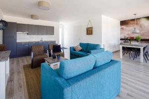 坎珀兰RCN Vakantiepark de Schotsman Bungalow de Boei的一间带蓝色沙发的客厅和一间厨房