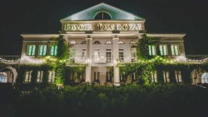 DwikozyDwór Dwikozy的白色的建筑,晚上有标志