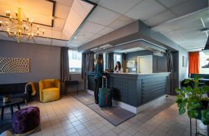 特罗姆瑟阿马利亚入住酒店的一名妇女带着行李站在柜台上,在沙龙