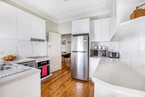 肯图巴峰会之家度假屋的厨房配有白色橱柜和不锈钢冰箱