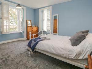 巴罗弗内斯Eastwood House的一间卧室配有一张蓝色墙壁和窗户的床