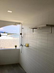 华欣PierView Rooms的带淋浴的浴室,享有海滩美景