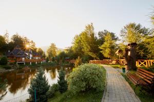 亚列姆切Ведмежа гора Family Resort & Spa的湖边的公园,有河流和长凳