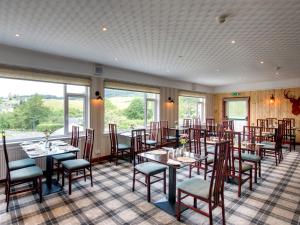 皮特洛赫里Craigvrack Hotel & Restaurant的用餐室设有桌椅和窗户。