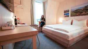 路德维希堡Hotel Bergamo的一位女士在旅馆房间,有床