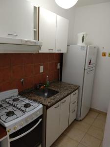 巴拉那Departamentos Carbó的厨房配有炉灶、水槽和冰箱。