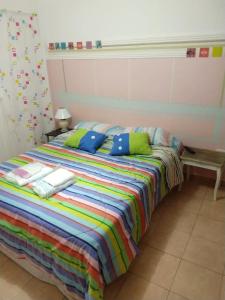 巴拉那Departamentos Carbó的床上有色彩缤纷的毯子和枕头
