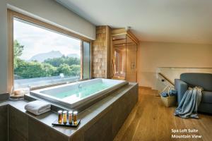 巴特莱辛哈尔Klosterhof – Alpine Hideaway & Spa的一间带大浴缸及大窗户的浴室
