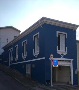 布拉干萨-保利斯塔Pousada Casa de Bragança II的蓝色的建筑,前面有一个车库