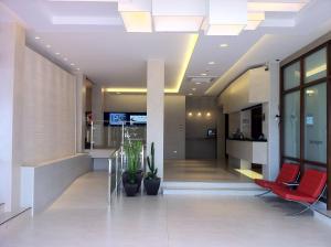 乌迪亚莱斯堡Las Rocas Playa Hotel的办公室大堂设有红色椅子和植物