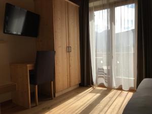 蒙圭尔福普拉策霍夫公寓酒店的一间卧室配有一张床、一台电视和一个窗口