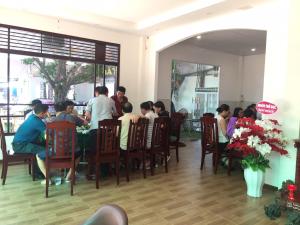 金瓯Thanh Truc Hotel Ca Mau的一群人坐在餐馆的桌子旁