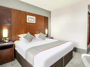 谢菲尔德OYO Flagship Sheffield City Centre的卧室配有一张白色大床和木制床头板