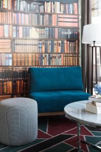 拉巴特Mgallery Le Diwan Rabat的客厅设有蓝色的沙发和大型图书馆。
