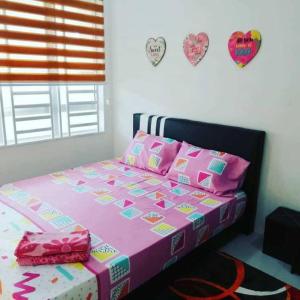 宋溪Nur Zahra Sungkai Homestay的卧室配有粉红色的床,墙上有心