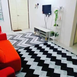 宋溪Nur Zahra Sungkai Homestay的客厅配有红色的沙发和黑白地毯。