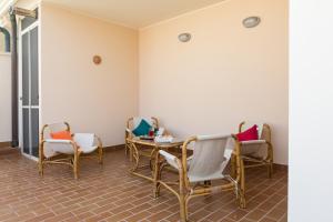 阿尔盖罗Viona Apartments的一间设有椅子和桌子的等候室
